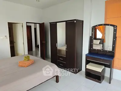 Spacious bedroom with modern wardrobe and vanity set, perfect for comfortable living.