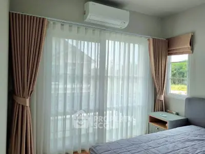 Bright bedroom with large window and modern air conditioning unit
