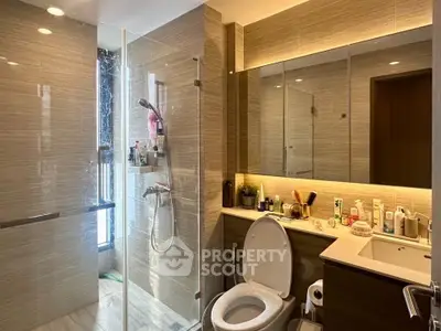 Modern bathroom with glass shower and sleek vanity in luxury apartment