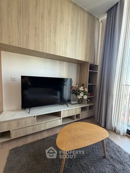 Modern living room with sleek TV unit and large window view