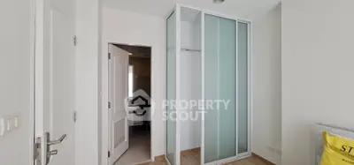 Modern bedroom with sleek sliding closet doors and en-suite bathroom access.