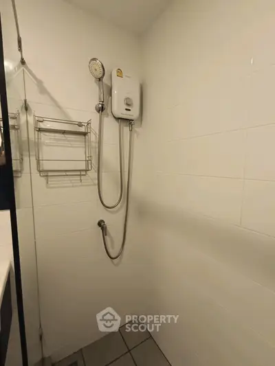 Compact bathroom with white tiles and modern shower unit