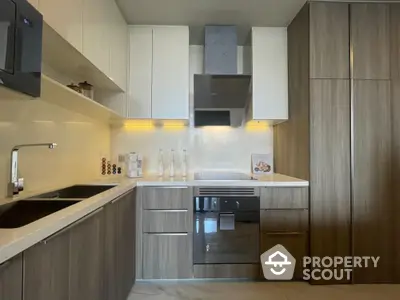 Modern kitchen with sleek cabinetry and built-in oven in a stylish apartment.