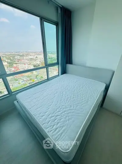 Bright bedroom with large window offering stunning city view, featuring a comfortable bed and modern decor.
