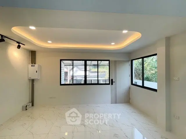 Modern living room with recessed lighting and large windows