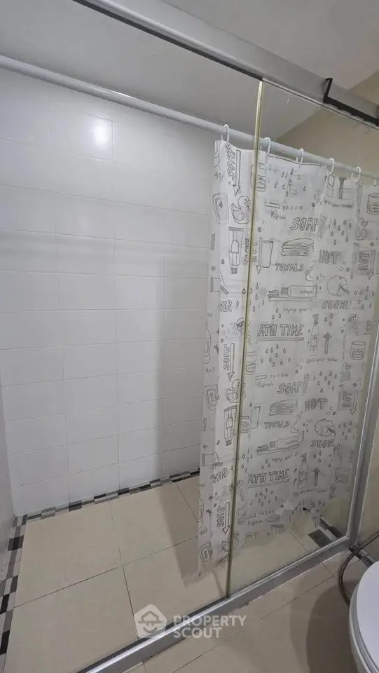 Modern bathroom with glass shower enclosure and decorative curtain