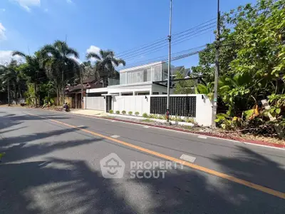 Modern luxury home with sleek design and lush greenery in a serene neighborhood.