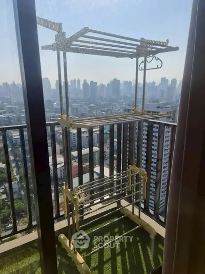 High-rise balcony with city view and drying rack, perfect for urban living.