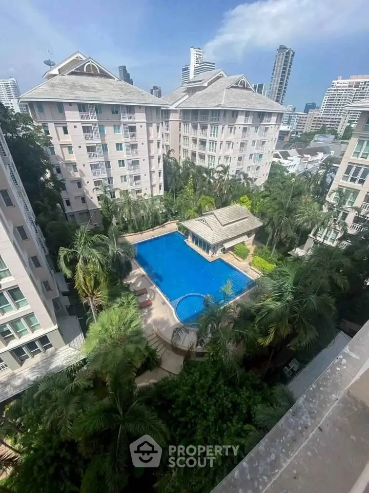 Luxurious residential complex with pool and lush greenery in urban setting