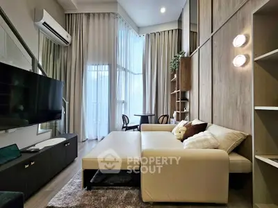Modern living room with high ceilings, stylish decor, and large windows for natural light.