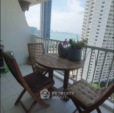 Spacious balcony with stunning city and ocean views, perfect for relaxation and outdoor dining.
