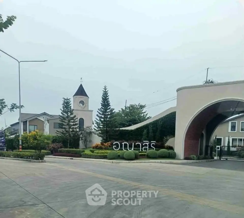 Charming residential entrance with clock tower and lush landscaping