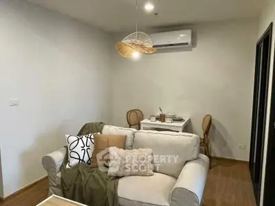 Cozy living room with modern decor and dining area, featuring air conditioning and stylish lighting.