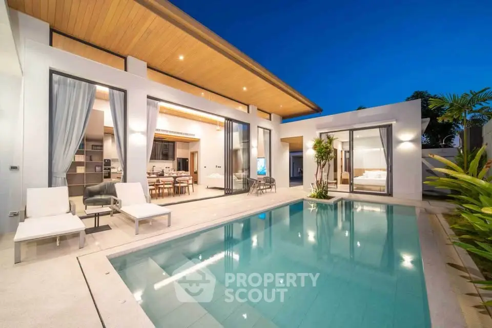 Luxurious modern villa with private pool and elegant outdoor seating area at dusk.