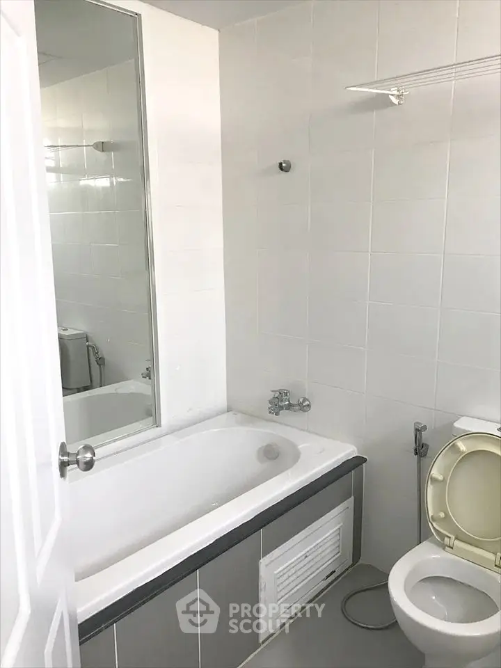Modern bathroom with bathtub and white tile design, perfect for relaxation.