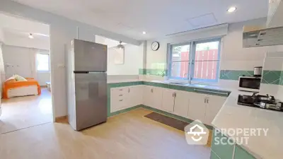 Spacious kitchen with modern appliances and open layout, featuring a view into a cozy bedroom.