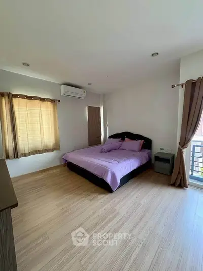 Spacious bedroom with natural light and modern decor in a stylish apartment.