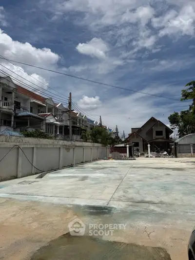 Spacious residential area with clear sky and modern houses, ideal for development.