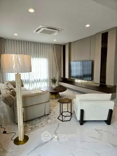 Luxurious modern living room with elegant furniture and large TV, perfect for relaxation and entertainment.