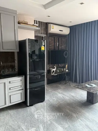 Modern living room with sleek kitchen appliances and elegant decor