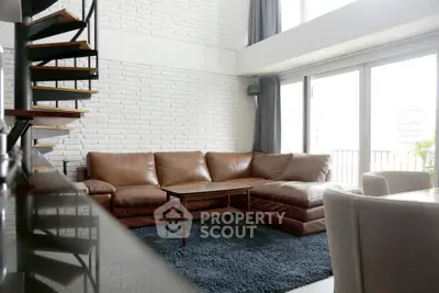 Spacious modern living room with leather sofa and spiral staircase