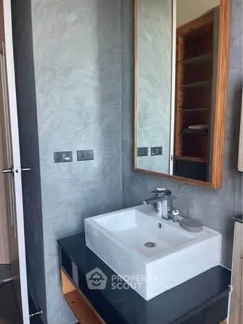 Modern bathroom with sleek sink and large mirror in stylish apartment.