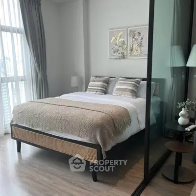 Modern bedroom with large window and stylish decor in a high-rise apartment.