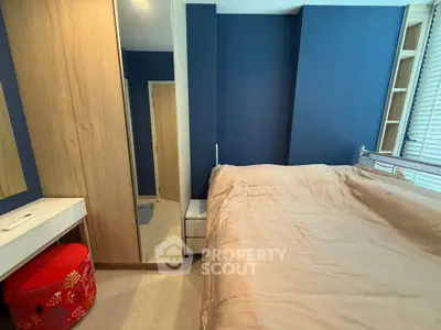 Cozy bedroom with modern blue accent wall and mirrored wardrobe