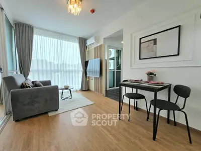 Modern living room with elegant decor and natural light, featuring a cozy sofa and dining area.