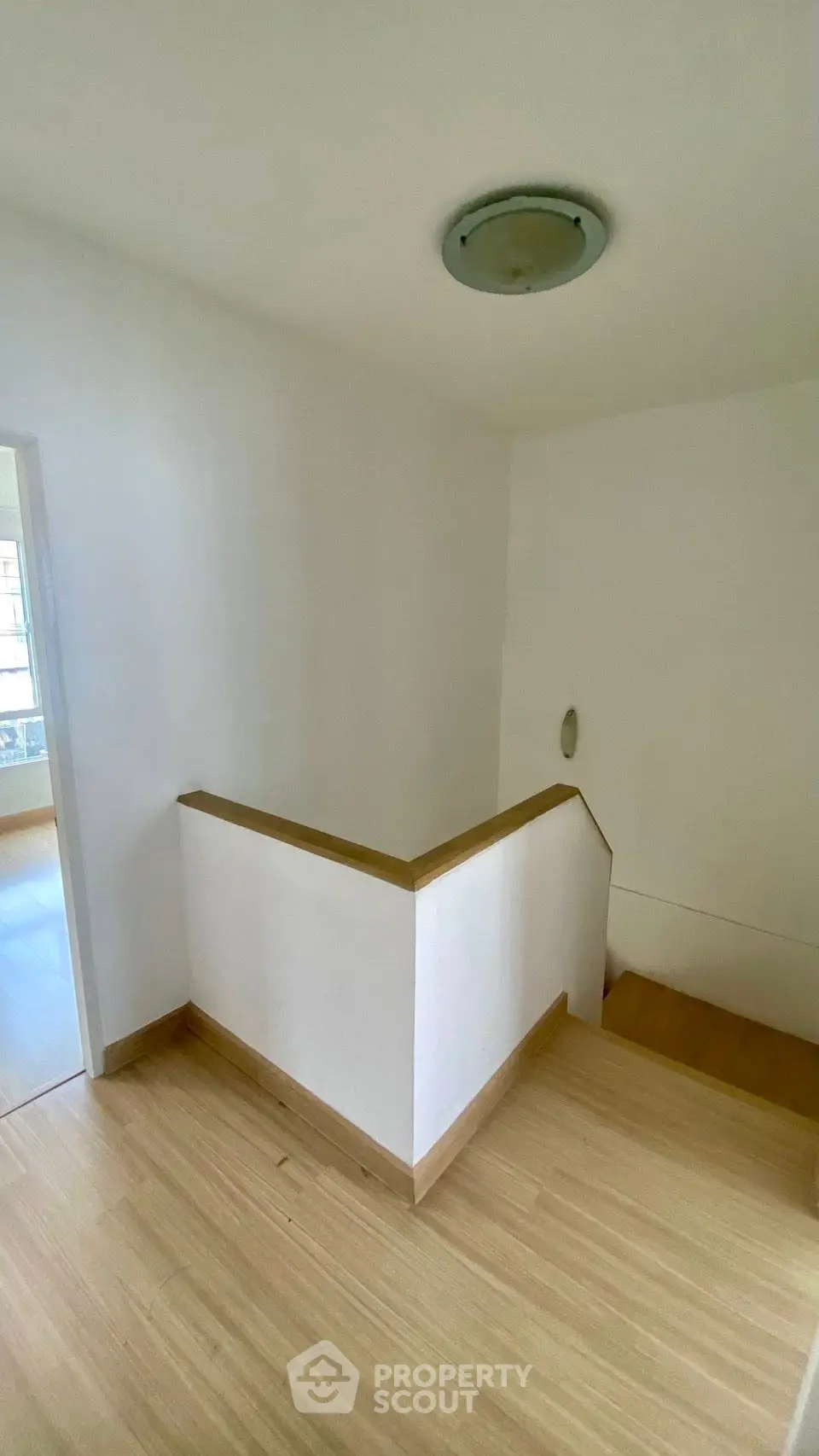 Bright and modern staircase with wooden flooring and minimalist design in a contemporary home.