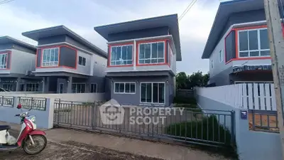 Modern two-story house with large windows and gated driveway in a suburban neighborhood.