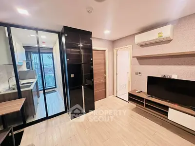 Modern living room with sleek design, featuring glass partition, air conditioning, and stylish shelving.