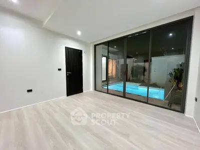 Modern living room with pool view and sleek wooden flooring