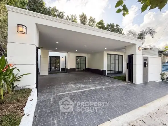 Modern house exterior with spacious driveway and elegant lighting.