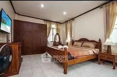 Spacious bedroom with wooden furniture and natural light