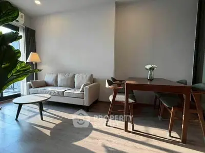 Modern living room with cozy sofa and dining area, featuring natural light and elegant decor.