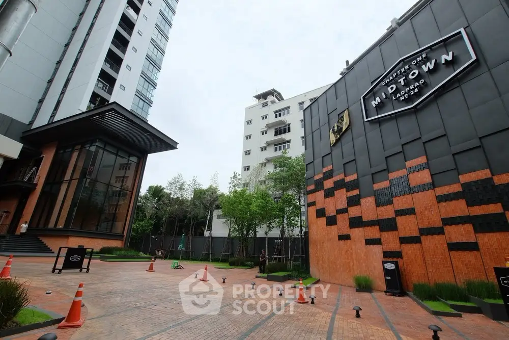 Modern building exterior with stylish brick design and lush greenery in a vibrant urban setting.