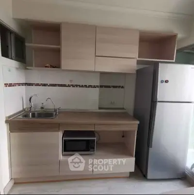 Modern compact kitchen with fridge and microwave in stylish apartment