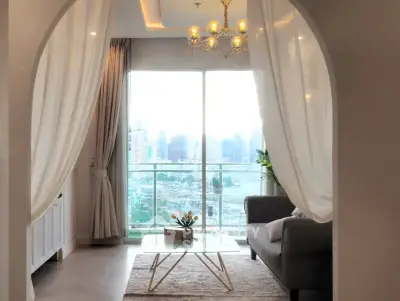 Elegant living room with city view, featuring modern decor and large windows.