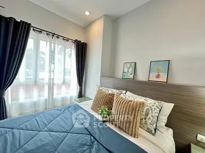Cozy bedroom with stylish decor and large window for natural light