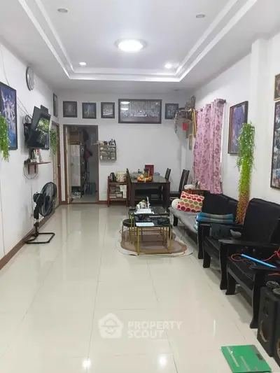 Spacious living room with modern decor and ample natural light, perfect for family gatherings.