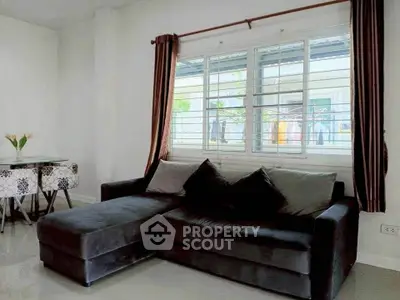 Modern living room with stylish dark sofa and elegant dining area