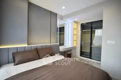 Modern bedroom with sleek design and neutral tones, featuring a large bed and stylish lighting.