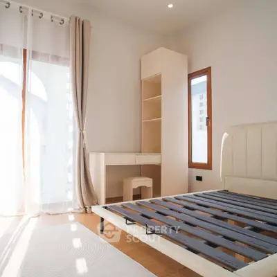 Bright bedroom with modern furniture and large window for natural light.