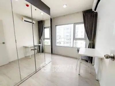 Spacious bedroom with mirrored wardrobe and large windows in modern apartment