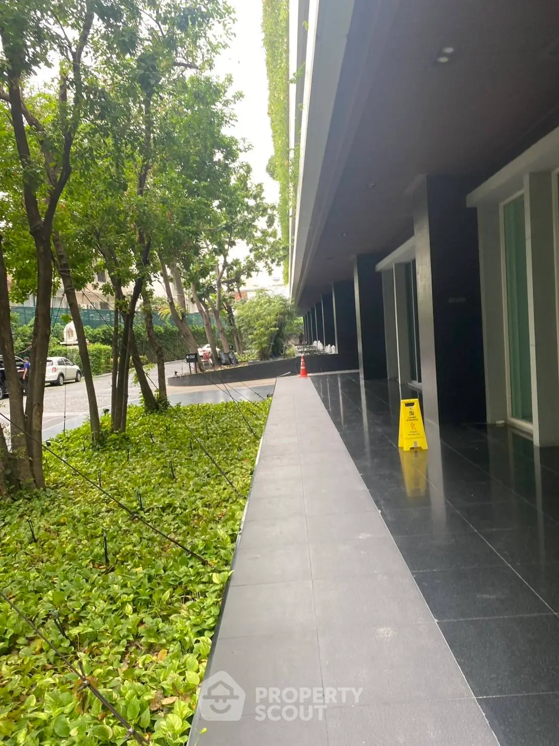 Modern building entrance with lush greenery and sleek walkway
