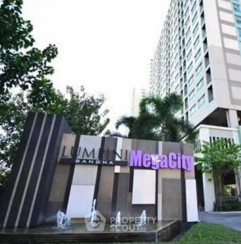 Modern high-rise building with lush greenery and stylish entrance signage at MegaCity Bangna.