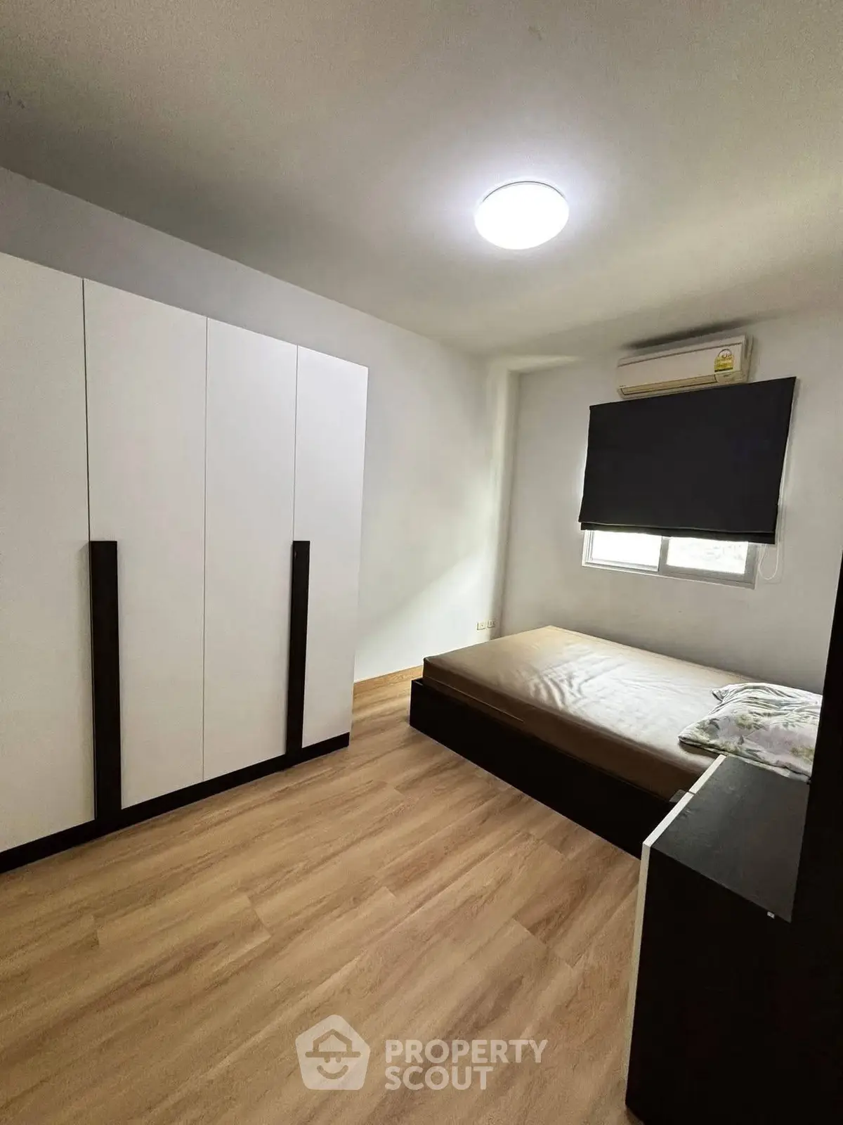Modern minimalist bedroom with sleek wardrobe and natural light