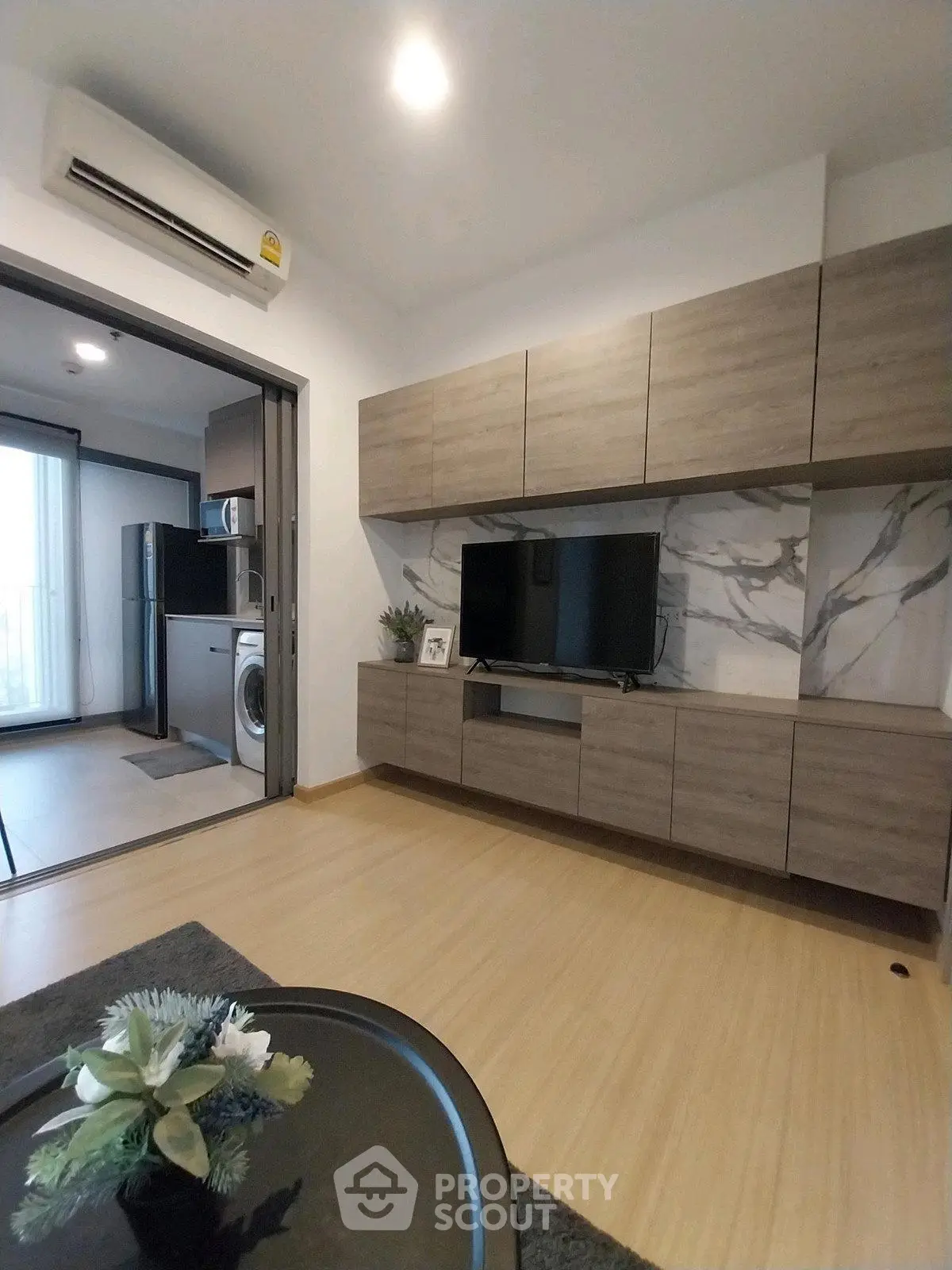 Modern living room with stylish wooden cabinets and open kitchen layout
