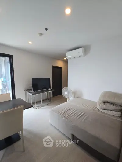 Modern living room with sleek furniture and air conditioning in a contemporary apartment.